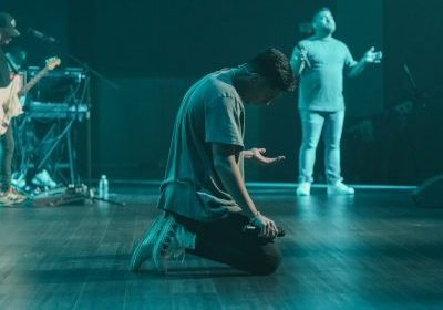 a man sitting on the floor in front of a microphone