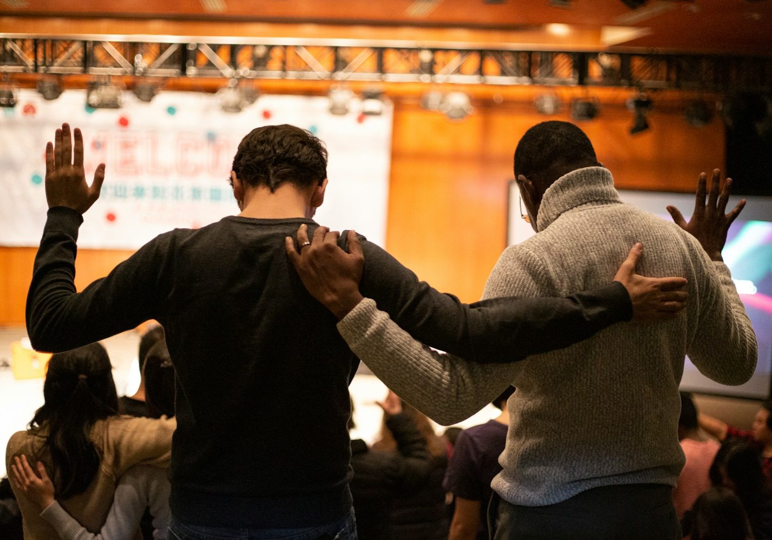 two men holding ear others hand